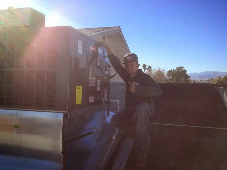 HVAC technician performing AC Tune-Up on a rooftop unit in Innsbrook